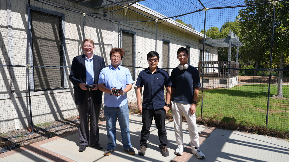 Peter Burke (left) and students test drone at 20 ft. by 20 ft. UCI drone cage