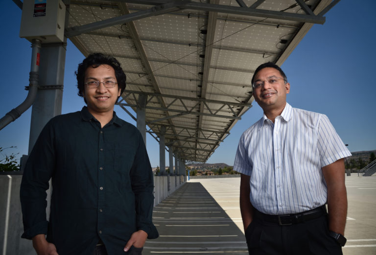 Anomadarshi Barua (left), a doctoral student in electrical engineering & computer science, and Associate Professor Mohammad Al Faruque stand within spoofing distance of a solar inverter on the UCI campus. They figured out a way to disrupt power grids using about $50 worth of equipment hidden in a disposable coffee cup. Steven Georges / UCI