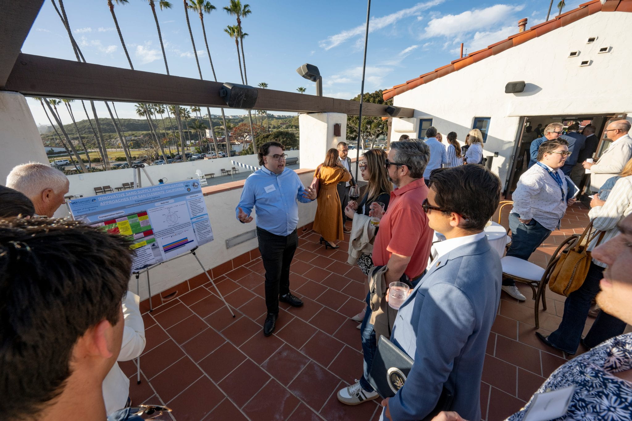 Jacob Samson (center), a graduate student in mechanical and aerospace engineering, leads a presentation about UC Irvine Climate Collaboration research to improve the resiliency of California’s coastline at a 2025 event in San Clemente. The UCICC operates on dual principles of interdisciplinary collaboration and engagement with external partners, including government agencies, community groups and businesses. Steve Zylius / UC Irvine