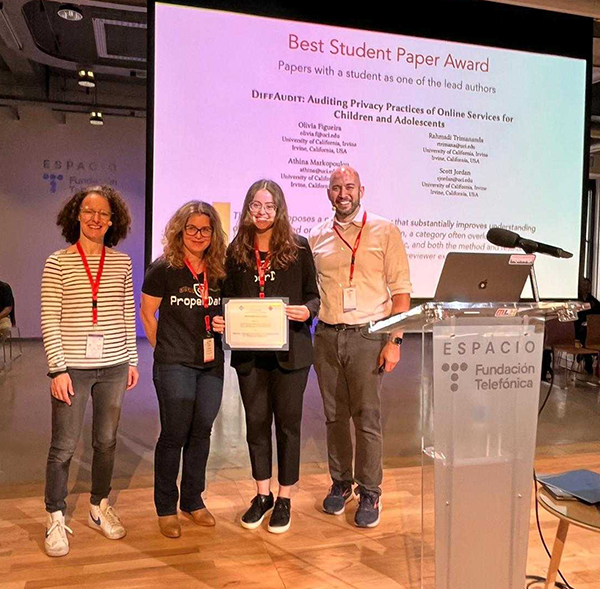 The IMC 2024 Program Committee Chairs Cristel Pelsser (left) and Dave Levin (far right) present the Best Student Paper Award to Athina Markopoulou (second from left) and Olivia Figueira.