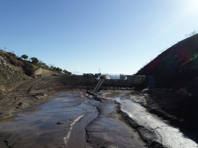 During a storm, debris basins fill up with loose soil, tree limbs and other materials. Once the level of mud and debris reaches the spillway, downstream communities are exposed to highly dangerous flooding. A new NSF-funded interdisciplinary research project at UCI aims to estimate the threat to people living below burn areas, accounting for the possibility that compounded events will contribute to the failure of flood-control infrastructure. Photo courtesy of Riverside County Flood Control.