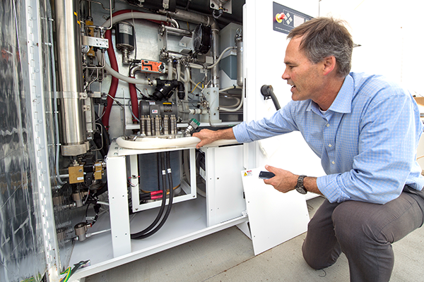 Jack Brouwer, UCI associate professor of mechanical & aerospace engineering and civil & environmental engineering, explains the workings of an electrolyzer, a key component of the power-to-gas system. The device uses renewable electricity to split water into oxygen and hydrogen. The oxygen is released into the atmosphere, and the hydrogen is injected into the natural gas supply line for UCI’s power plant. Steve Zylius / UCI