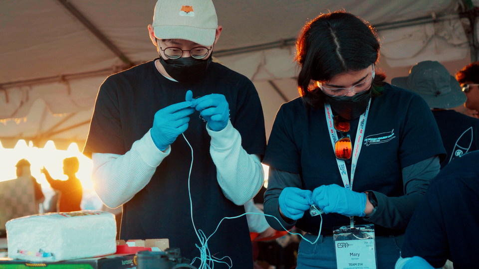 UCI Rocket Project Solids Avionics Software Lead Sean Liem (left) and Avionics Hardware Lead Mary Ajemyan (right) prepare ejection charges for the rocket’s parachutes. 