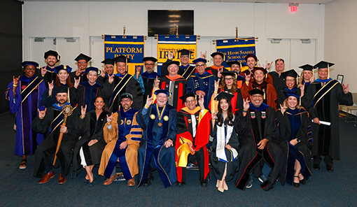 The Samueli School of Engineering commencement platform party practices their Zot, Zot, Zot! backstage.