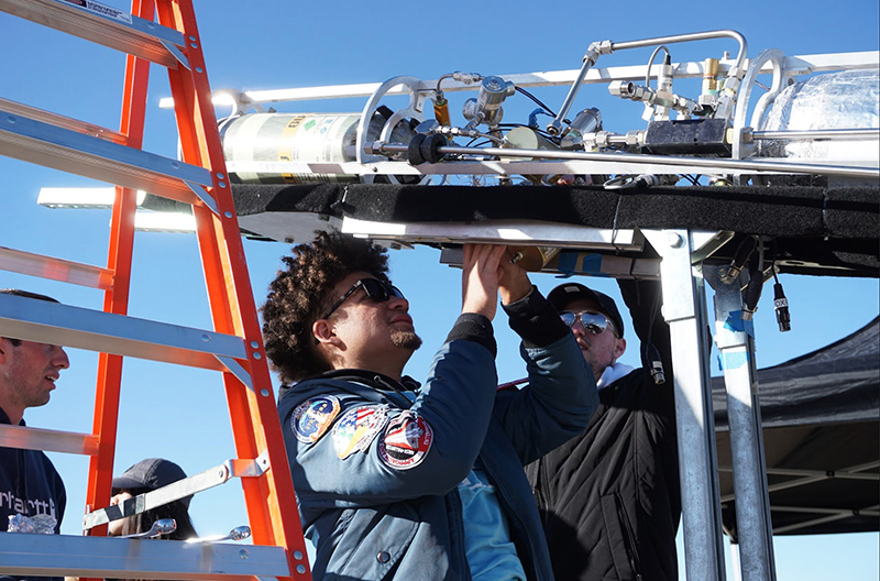 Quincy Barnes (middle) helps set up the methalox rocket