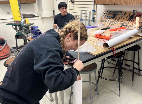 Students work on sealing their rocket's internal chamber, allowing for the safe deployment of their recovery device.