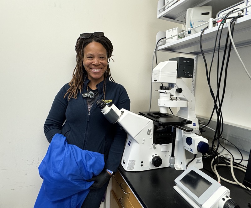 Ronke Olabisi and the inverted microscope that she uses to view cells in petri dishes in her UCI lab. (Photo: Natalie Tso/UCI)