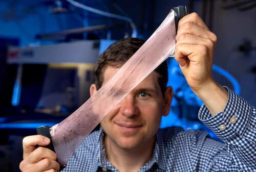 Alon Gorodetsky holds up material created in his lab that can regulate its temperature. (Steve Zylius/UCI)