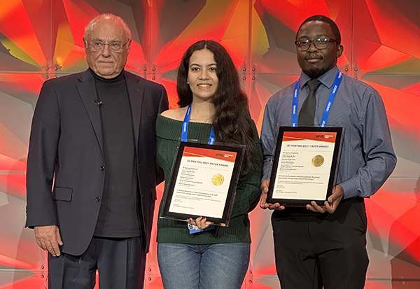 Electrical engineering and computer science graduate students Anita Ghandehari (center) and Shingirirai Chakoma (right) accept the Best Paper Award on behalf of their team at the SPIE Photonics West 2025 conference.